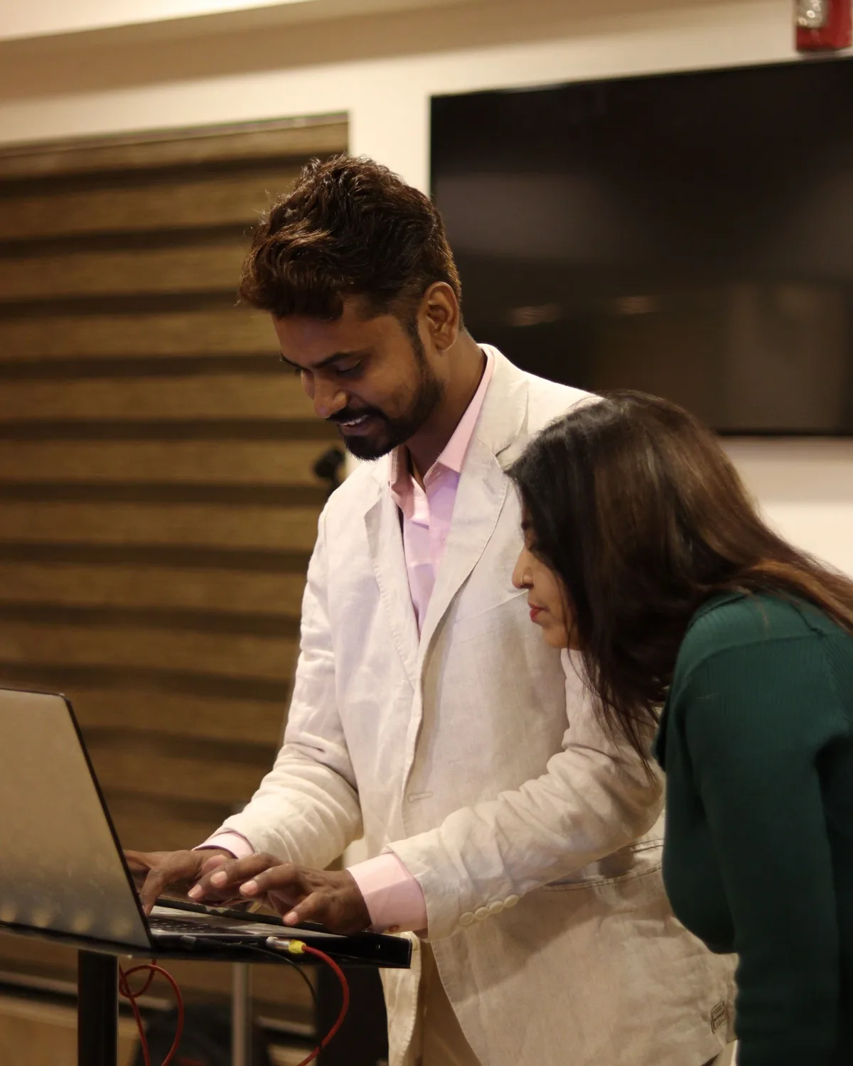 Two insurance professionals collaborating over a laptop in an office, representing advisory work at Wise Insurance