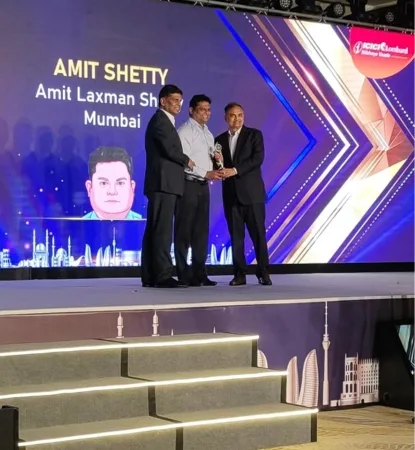 A Wise Insurance representative receiving a recognition award on stage at an ICICI Lombard event