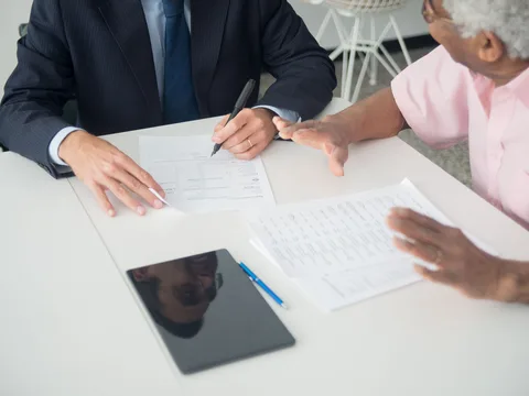 Insurance advisor reviewing a policy application document with a client
