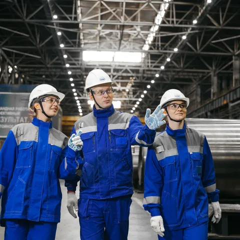 An industrial worker in safety gear on a factory floor