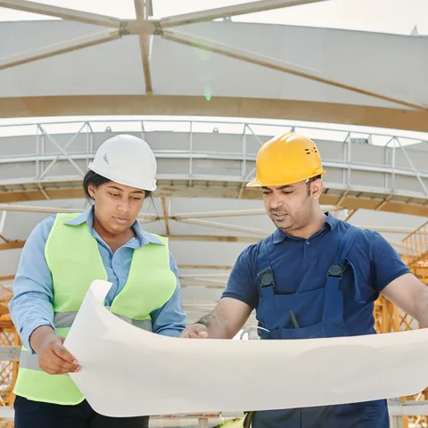 An engineer reviewing building plans on-site